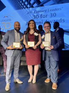 Three of Reinhardt's alumni pose with awards