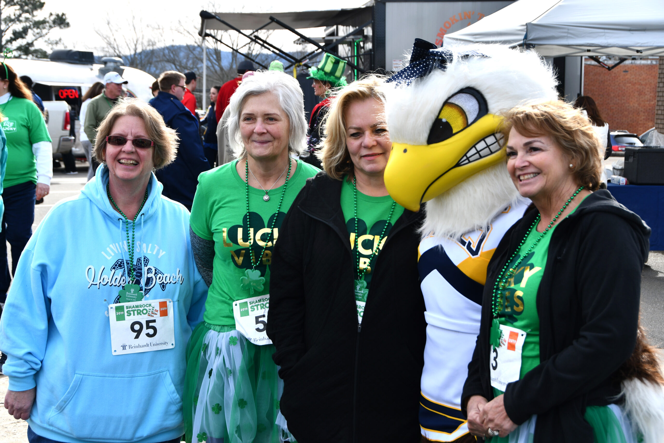 Three race participants pose with the Lady Soar eagle mascot