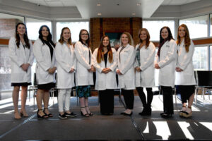 Reinhardt's fifth cohort of nursing students standing in a line on stage