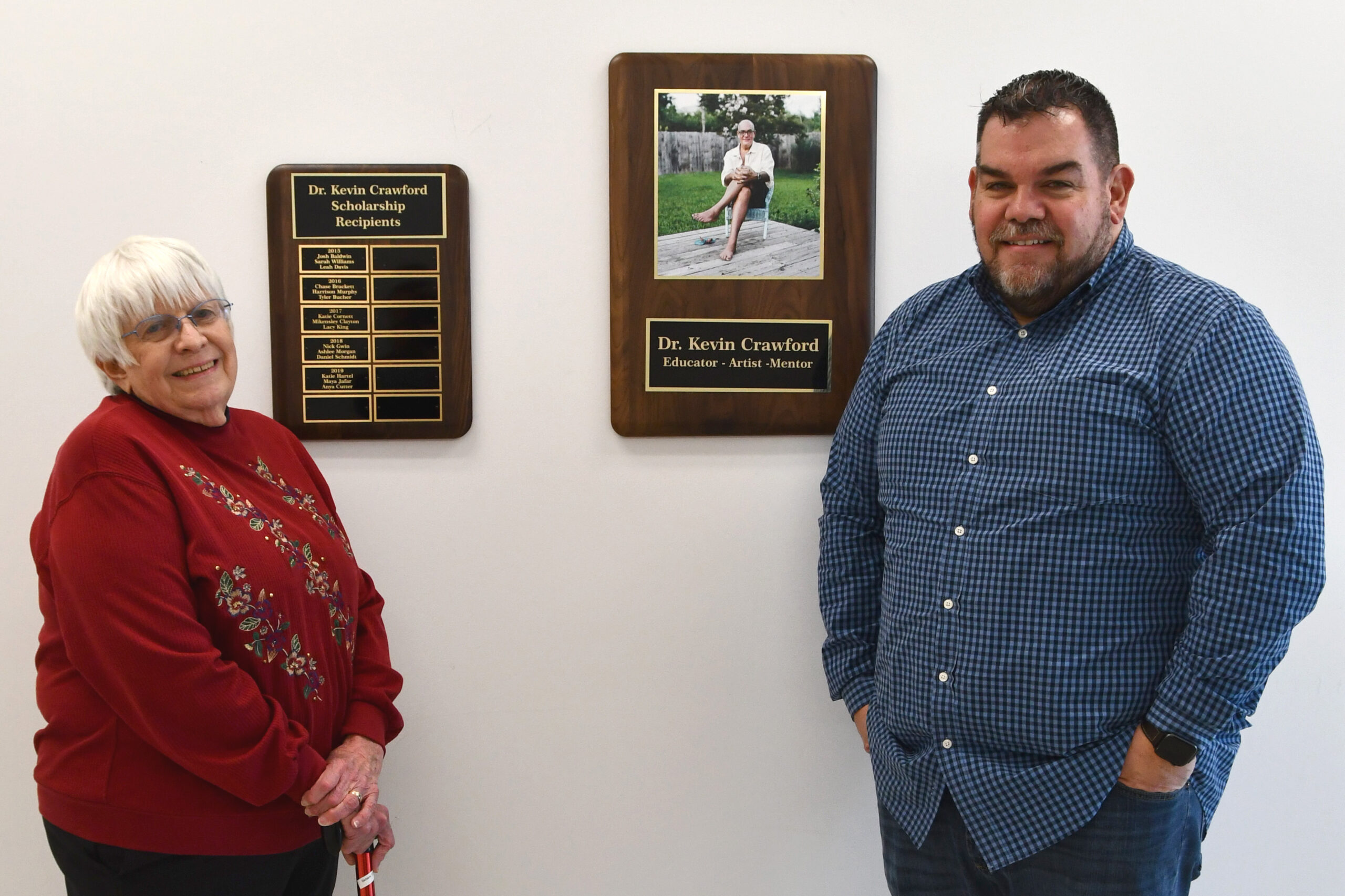Barbara and Todd Crawford stand with Dr. Kevin Crawford's plaques.