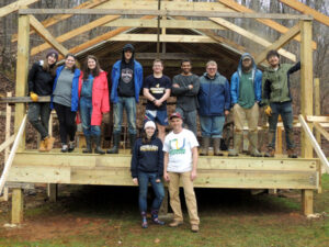 students stand on and in front of a wooden deck